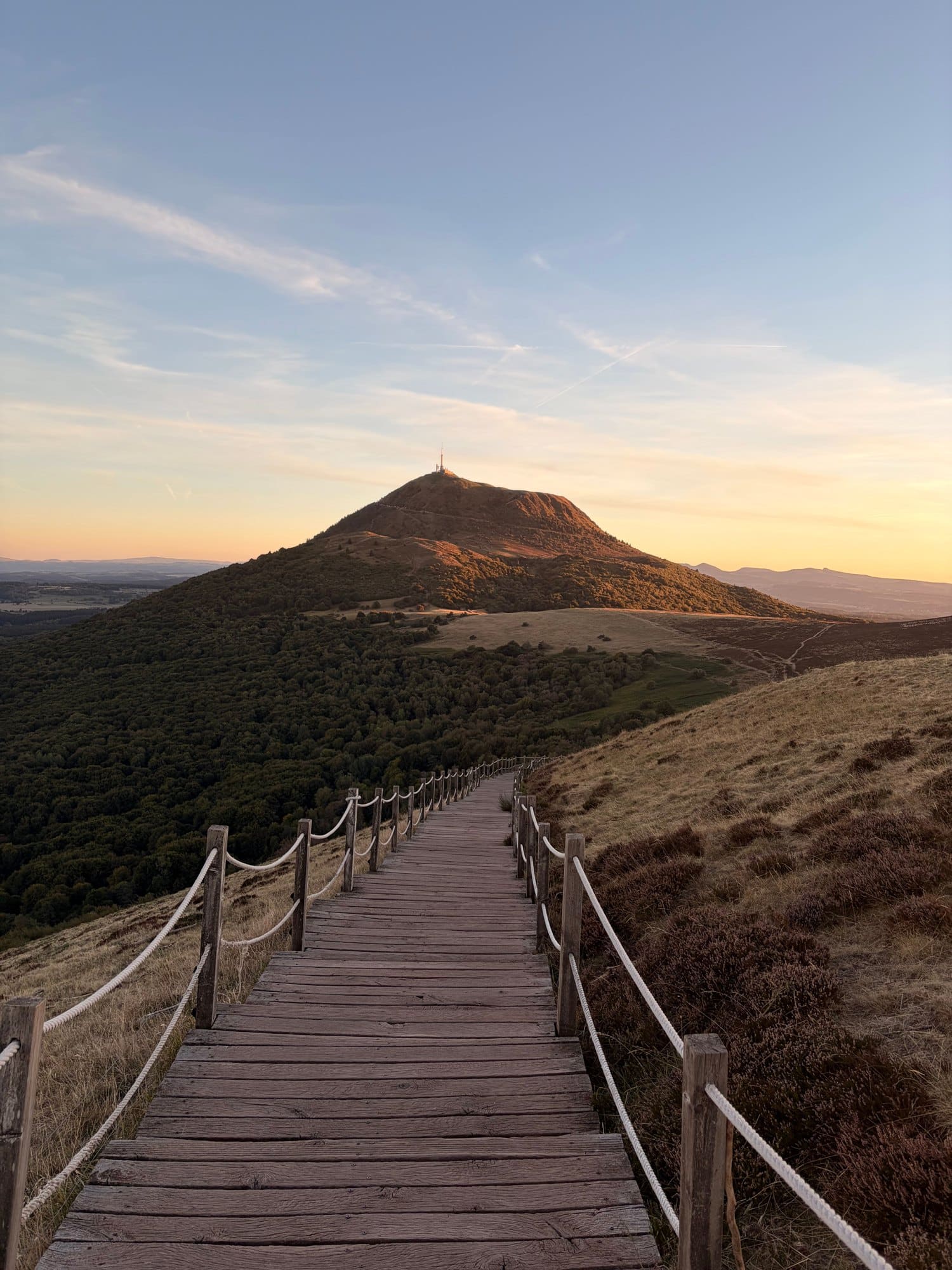 Chemin de bois menant au puy de Dôme au coucher du soleil